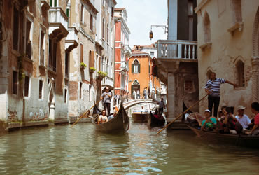 A gondolier with tourists in a Venetian canal