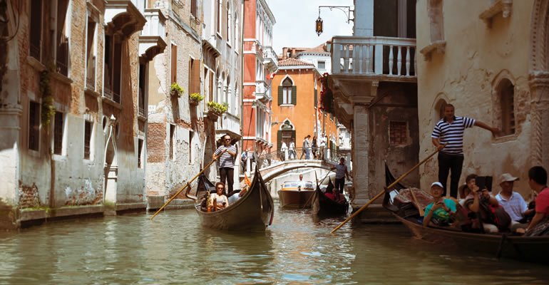 A gondolier with tourists in a Venetian canal