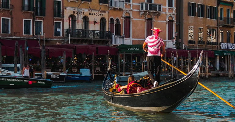 A gondolier with tourists in a Venetian canal