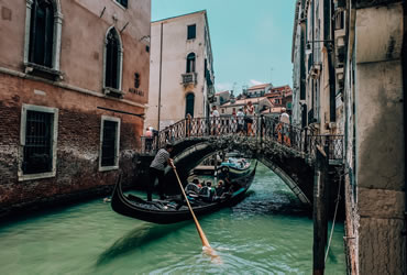 A gondolier with tourists in a canal in Venice