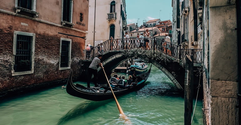 A gondolier with tourists in a canal in Venice