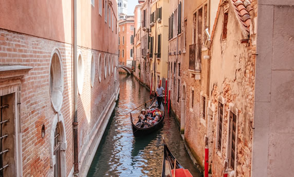 Un gondoliere con turisti in un canale di Venezia